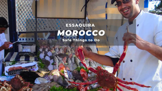 Cheerful fish vendor displays seafood at market stall in Essaouira, Morocco under the "Safe Things to Do" banner.