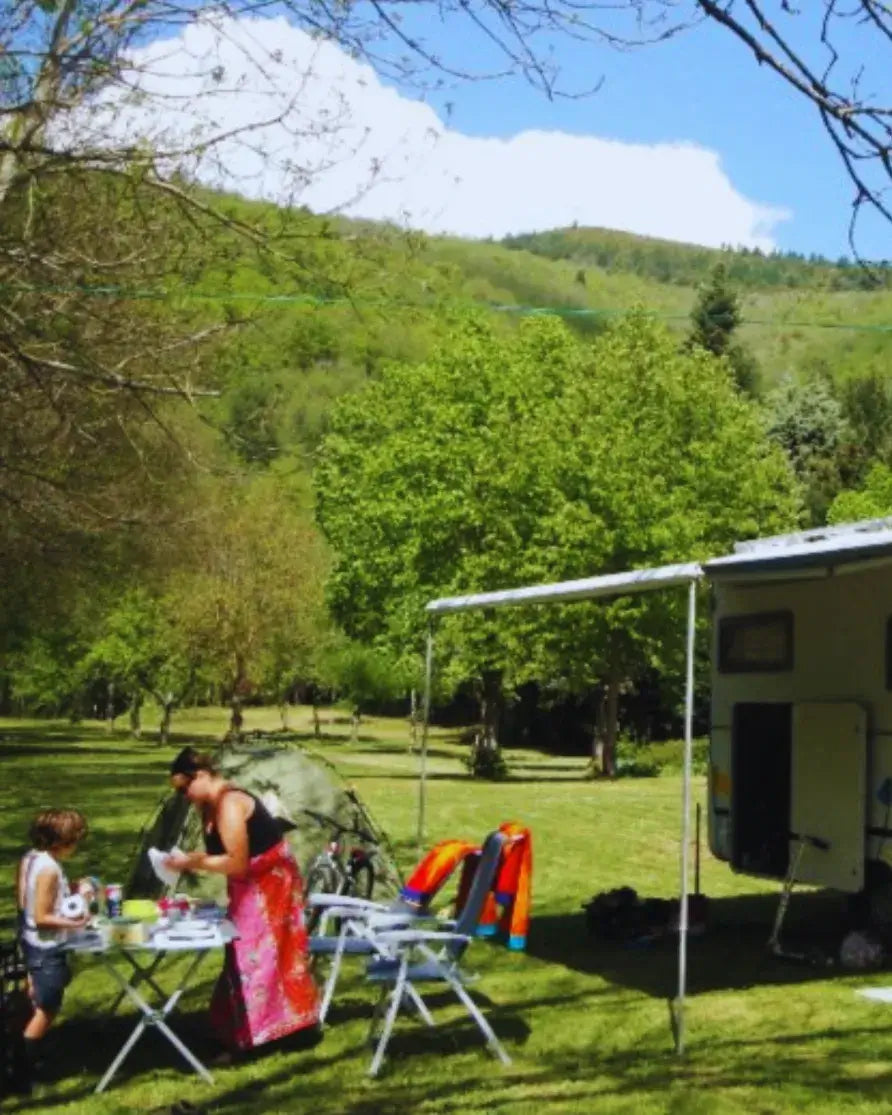founder woopies world travel blog cooking at campsite with campervan in green valley, slow travel lifestyle, outdoor travel blog image Europe